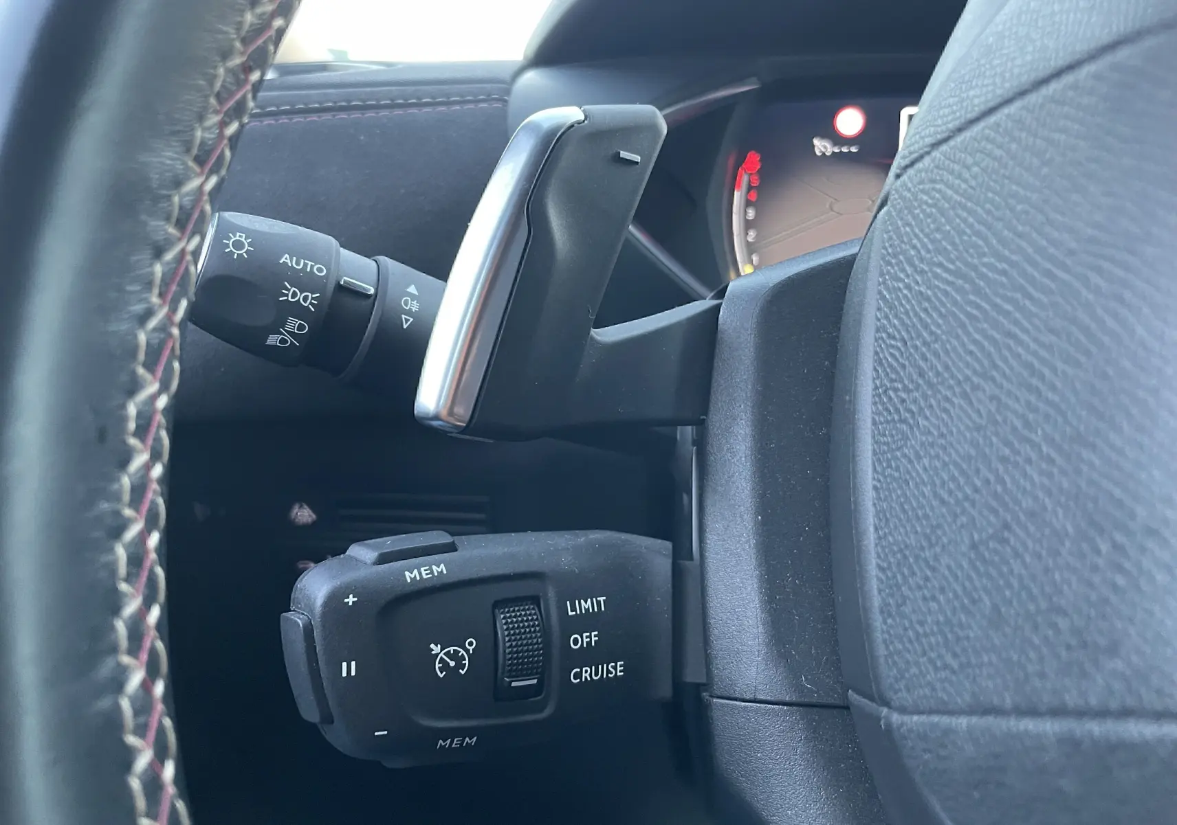 Gros plan sur la commande de régulateur de vitesse et levier de vitesses au volant d’un DS3 Crossback noir métal 2021.