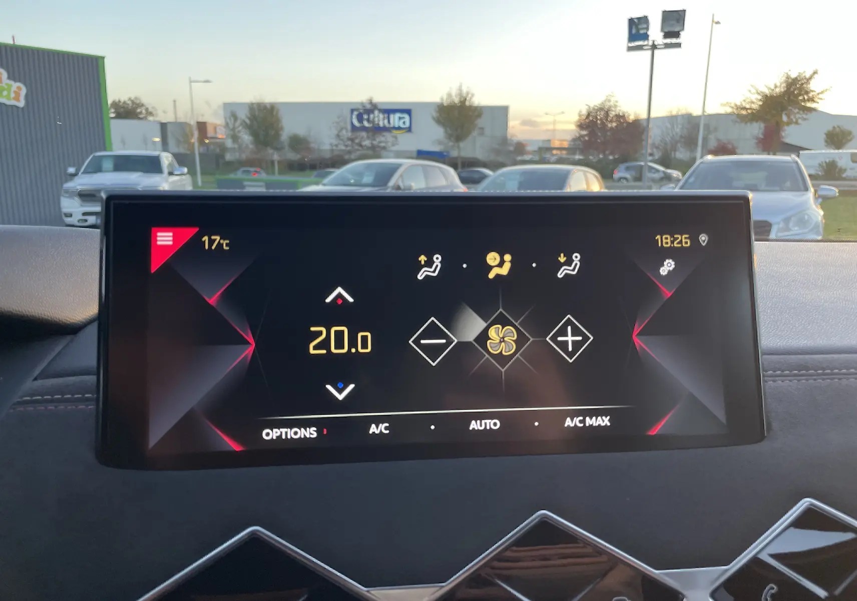 Écran tactile du système de climatisation du DS3 Crossback 2021 affichant 20°C, avec tableau de bord noir et extérieur flou.