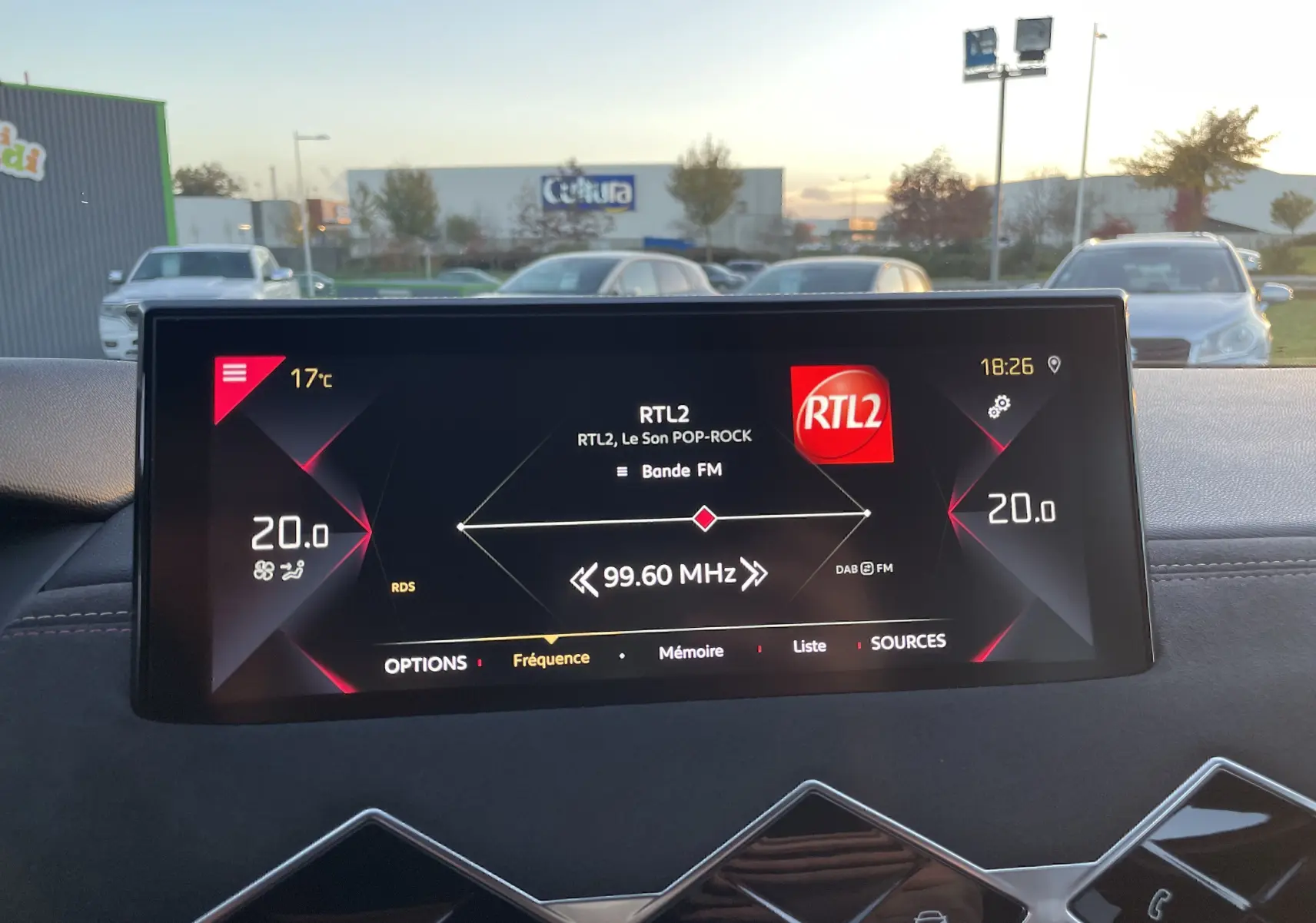 Écran tactile central du DS3 Crossback 2021 affichant la radio RTL2, avec tableau de bord noir et ciel en arrière-plan.