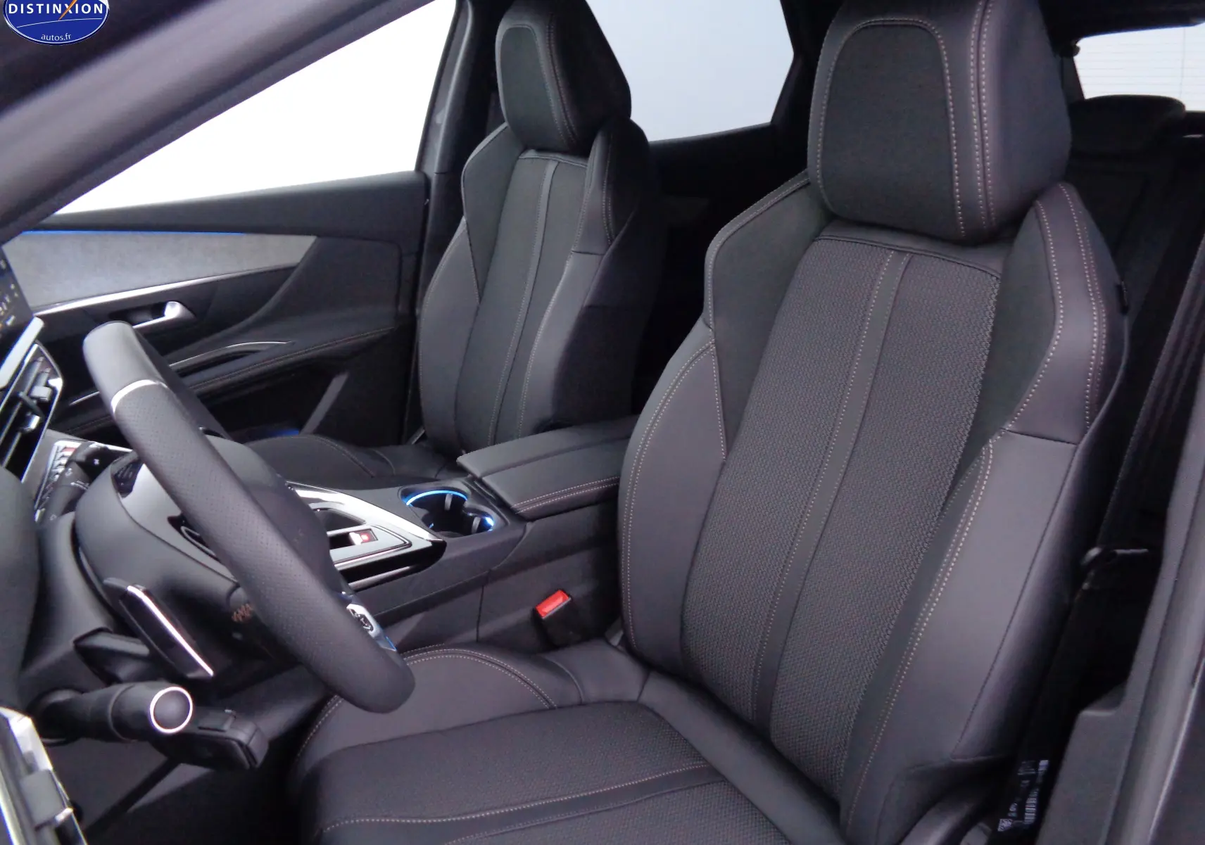 Vue intérieure côté conducteur du Peugeot 3008 2023, sièges en cuir noir avec surpiqûres contrastantes.