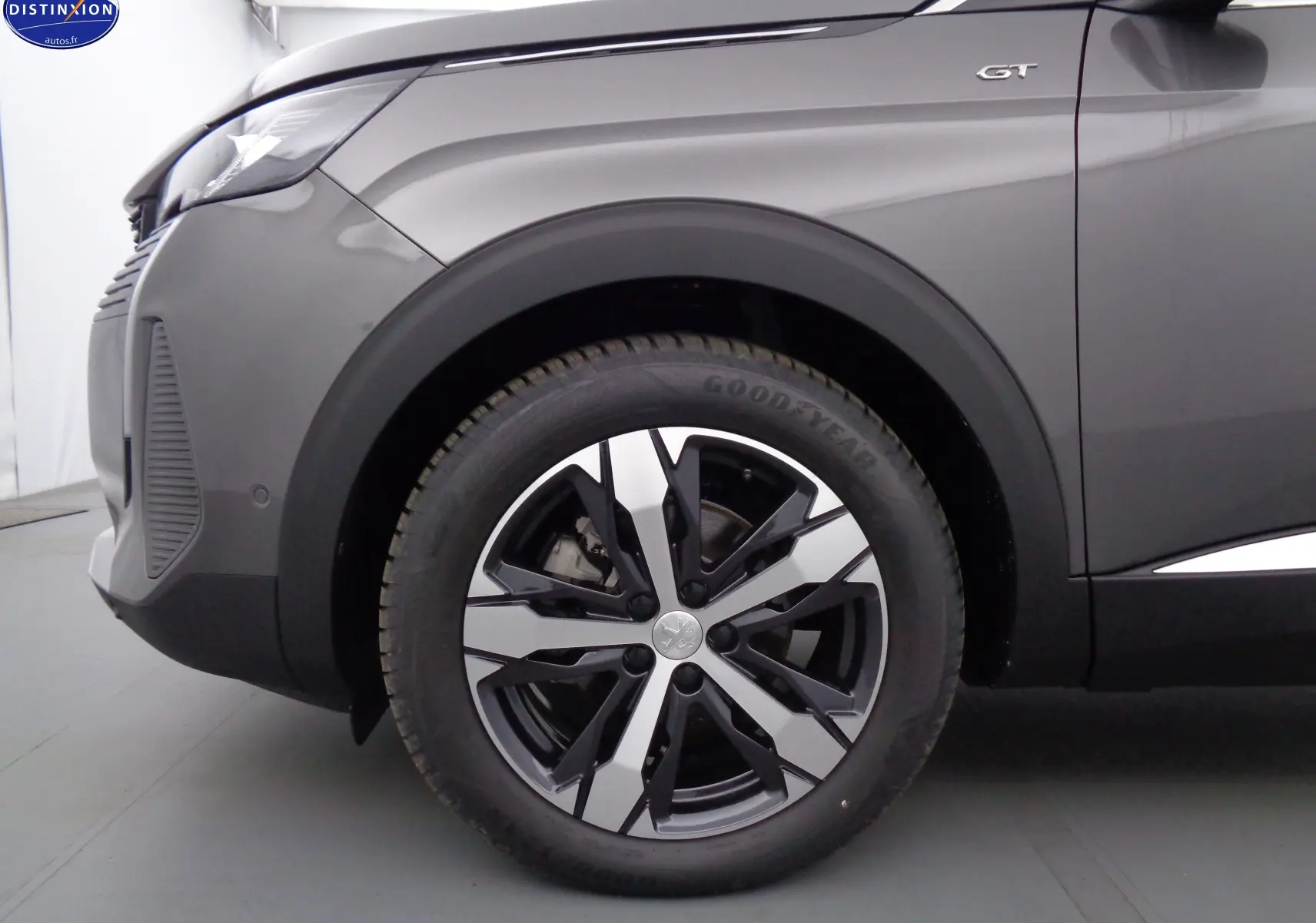 Gros plan sur la roue avant gauche et l'aile gris platinium d'un Peugeot 3008 GT avec logo GT visible.