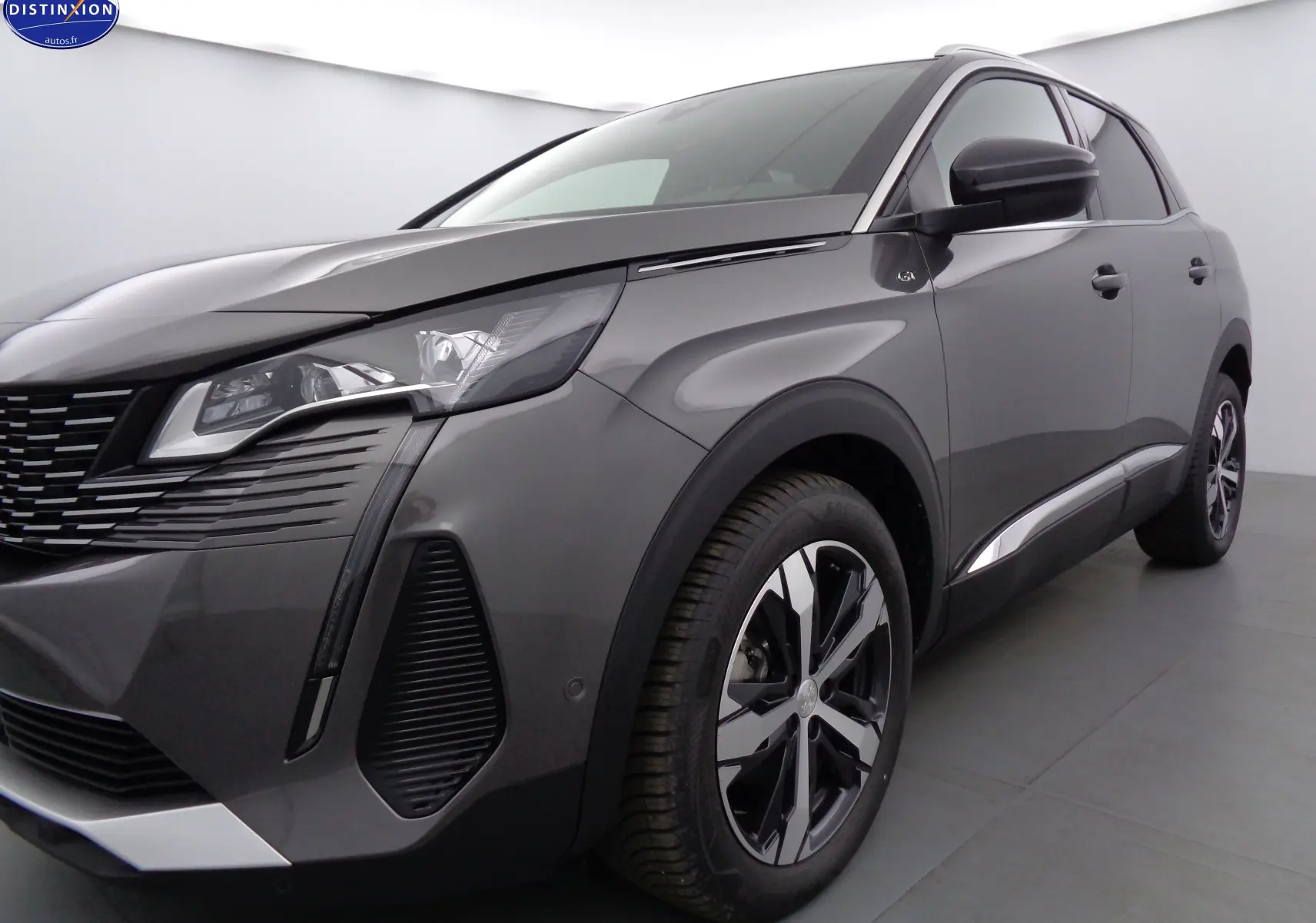 Vue 3/4 avant droit d'un Peugeot 3008 gris platinium métal avec jantes noires et détails chromés.