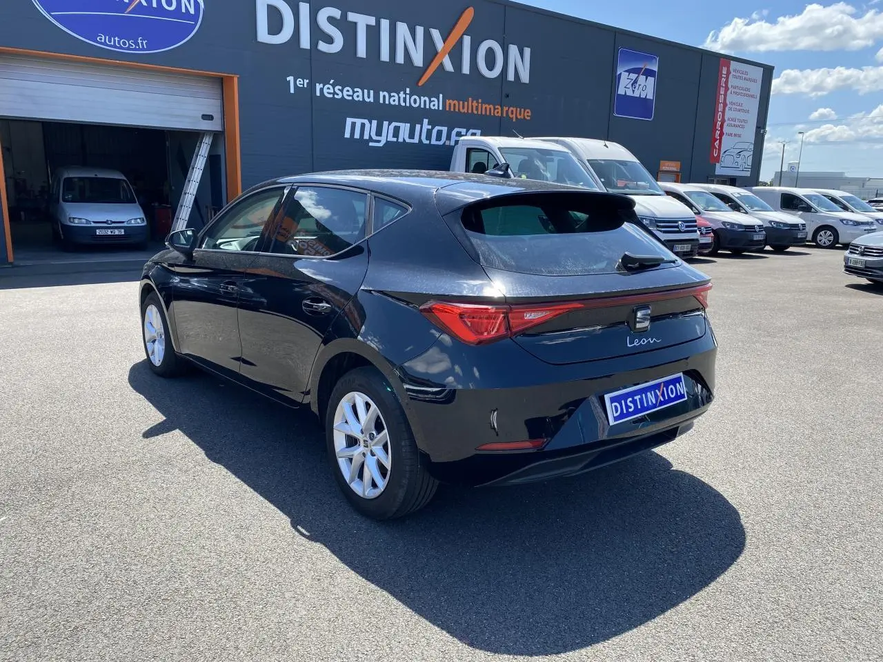 Vue 3/4 arrière droite d'une SEAT Leon 2024 noire Midnight avec vitres surteintées et feux arrière allongés.