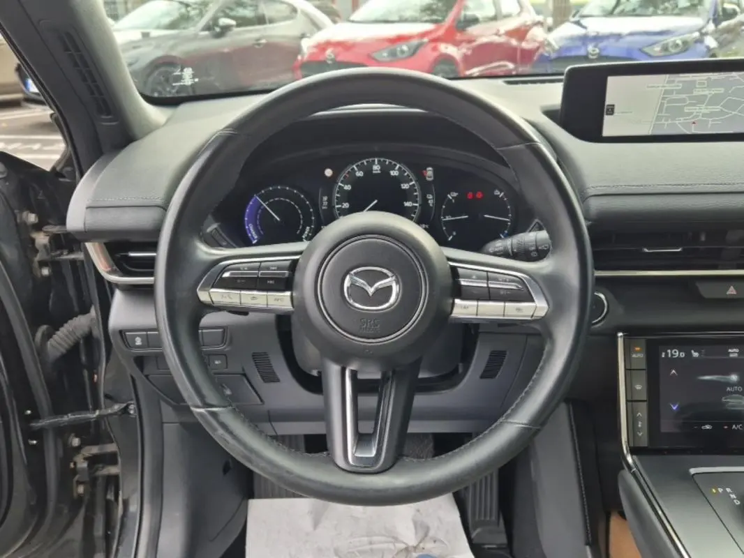 Vue centrée sur le volant noir du Mazda MX-30 électrique 2021 avec tableau de bord et écran tactile visibles.