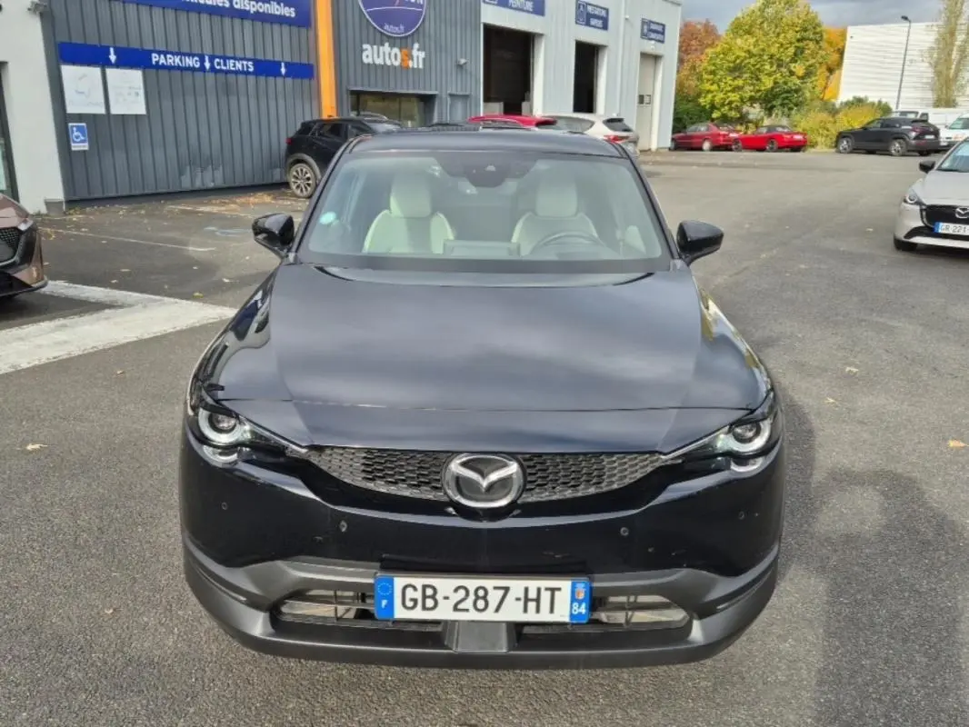 Vue frontale d'une Mazda MX-30 électrique noire 2021 avec intérieur clair et calandre distinctive.