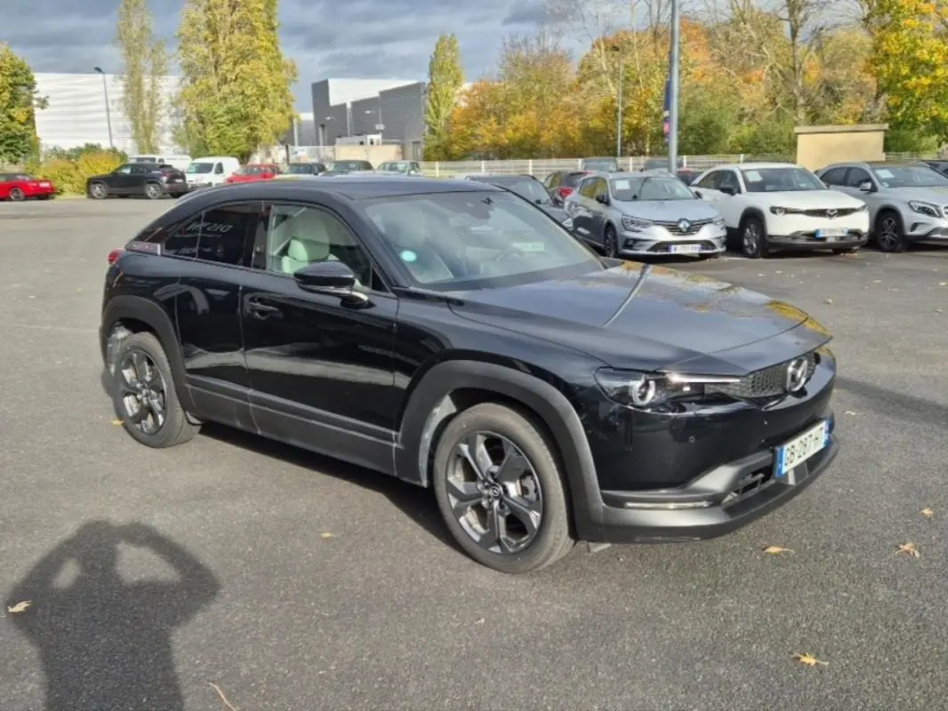 Mazda MX-30 électrique noire vue en 3/4 avant droit, avec ses jantes distinctives et ses lignes épurées modernes.