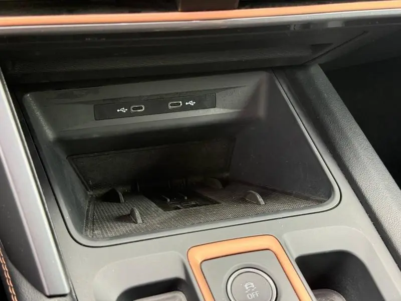 Gros plan sur la console centrale du CUPRA Formentor 2025, montrant les ports USB-C et un rangement noir mat avec surpiqûres orange.