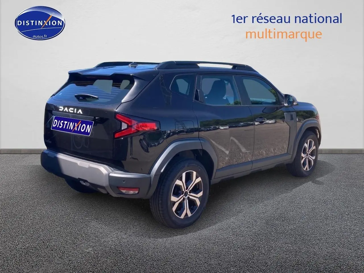 Vue 3/4 arrière droite d'un Dacia Duster noir 2025 avec barres de toit et jantes alu distinctives.