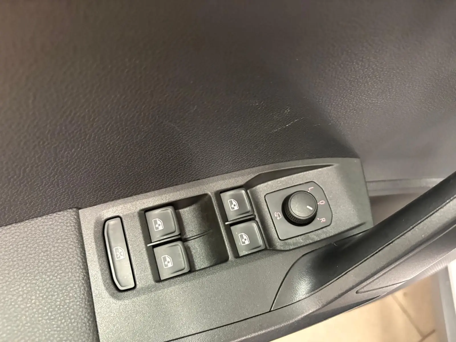 Commandes des vitres électriques et réglage des rétroviseurs côté conducteur du SEAT ARONA 2024 en plastique noir.