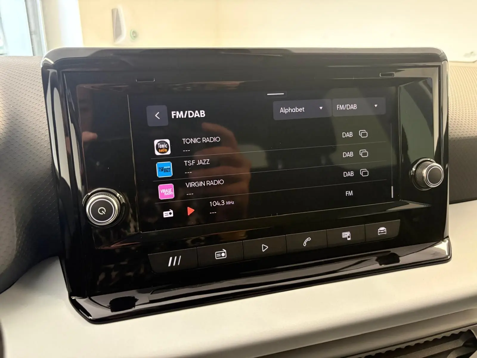 Écran tactile central du SEAT Arona 2024 affichant les stations FM/DAB avec finition intérieure sobre et moderne.