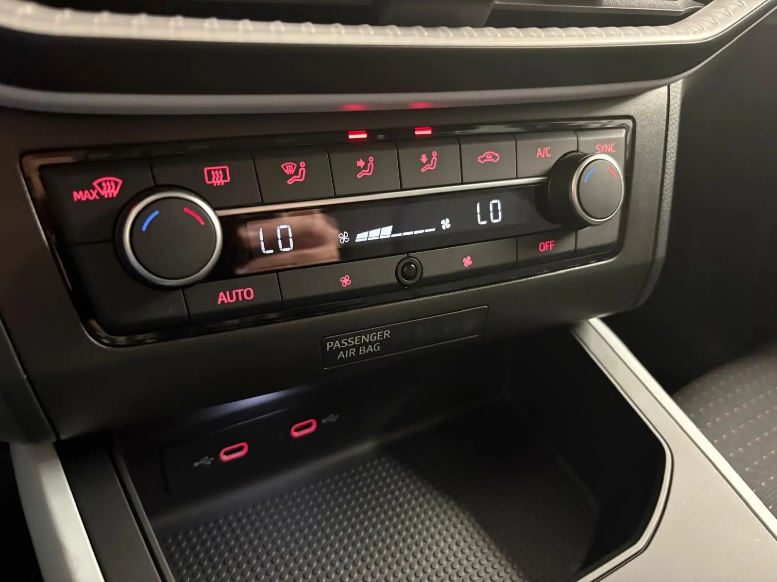 Tableau de bord du SEAT Arona 2024 montrant la climatisation digitale avec commandes rétroéclairées en rouge.