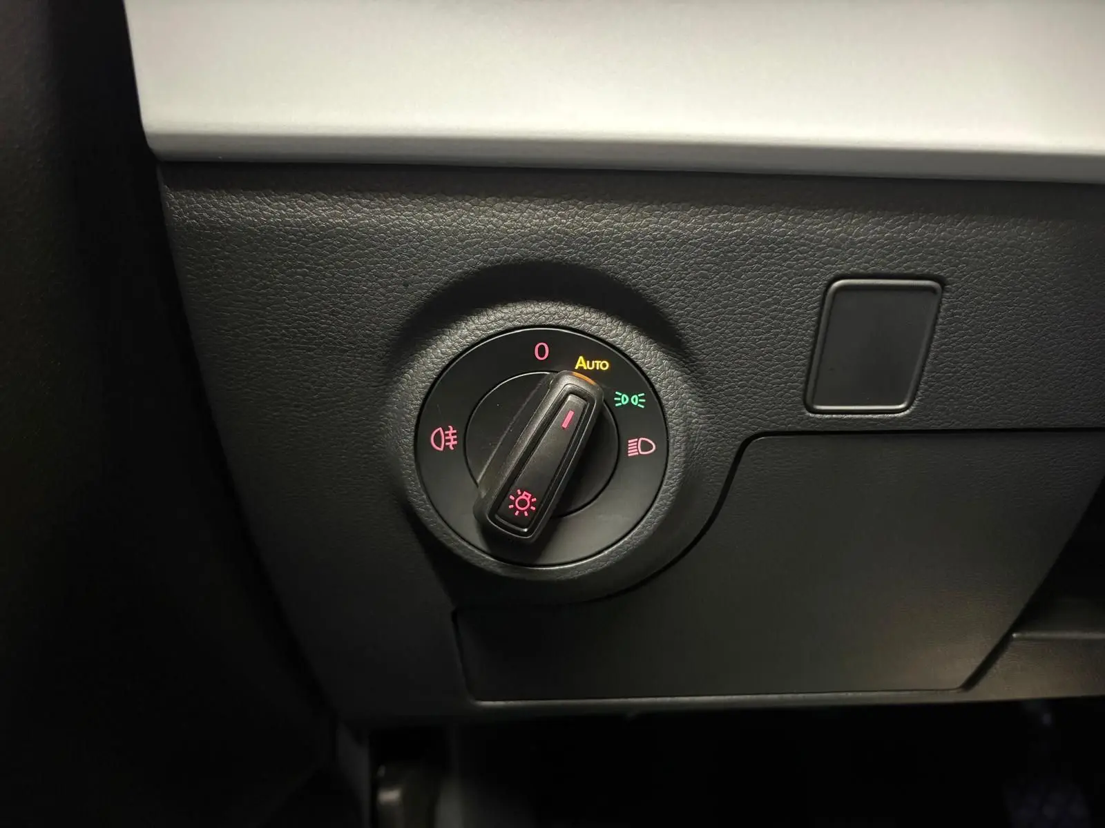 Commande des phares en gros plan sur le tableau de bord noir d'un SEAT Arona Gris Urbain 2024