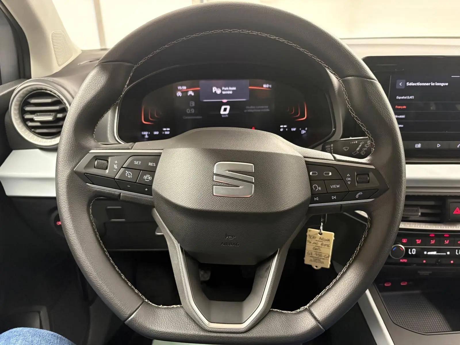 Vue intérieure centrée sur le volant cuir du SEAT Arona 2024 avec commandes intégrées et tableau de bord digital.