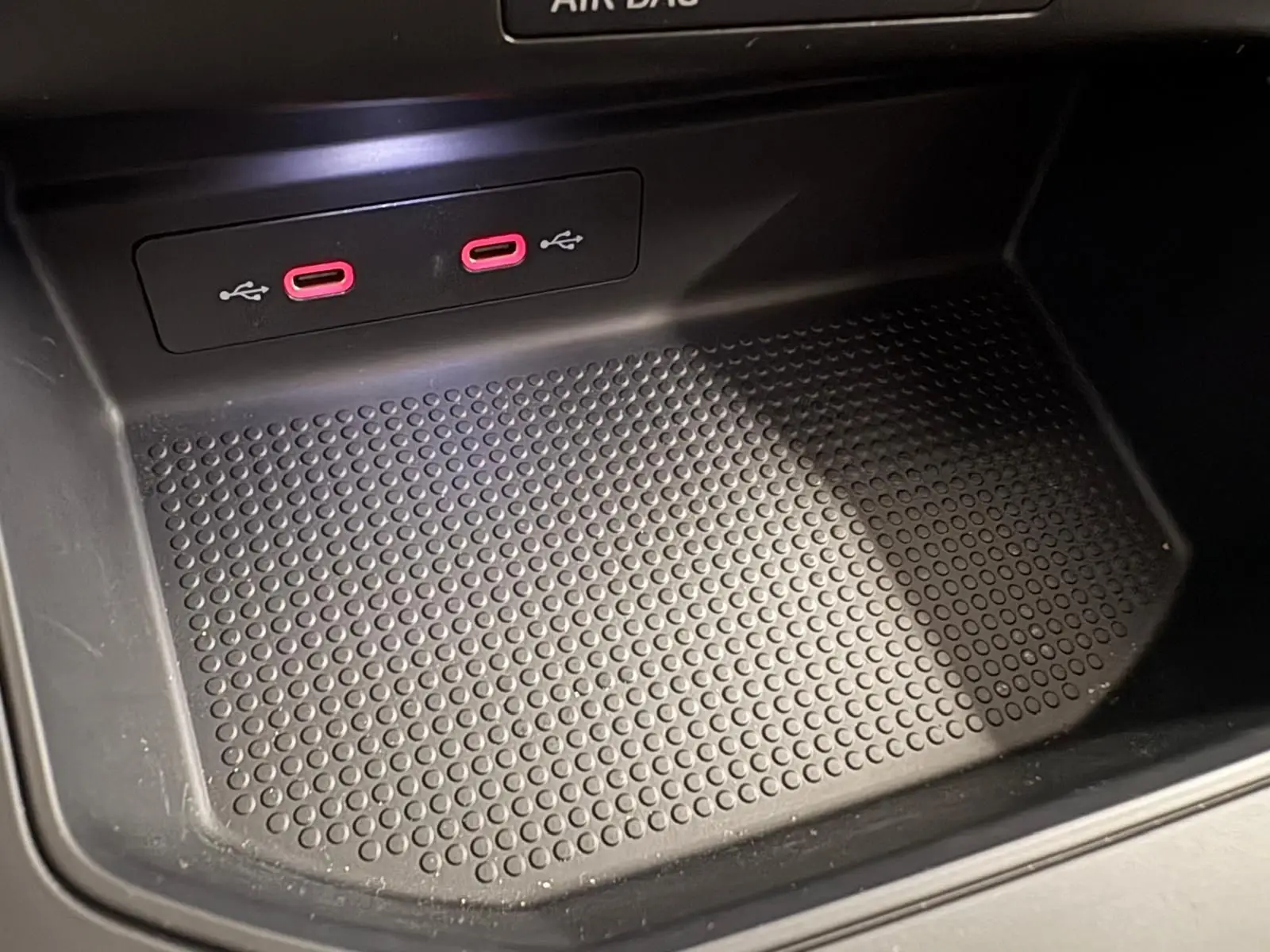 Gros plan sur la console centrale du SEAT Arona 2024 avec deux ports USB-C rouges et surface antidérapante noire.