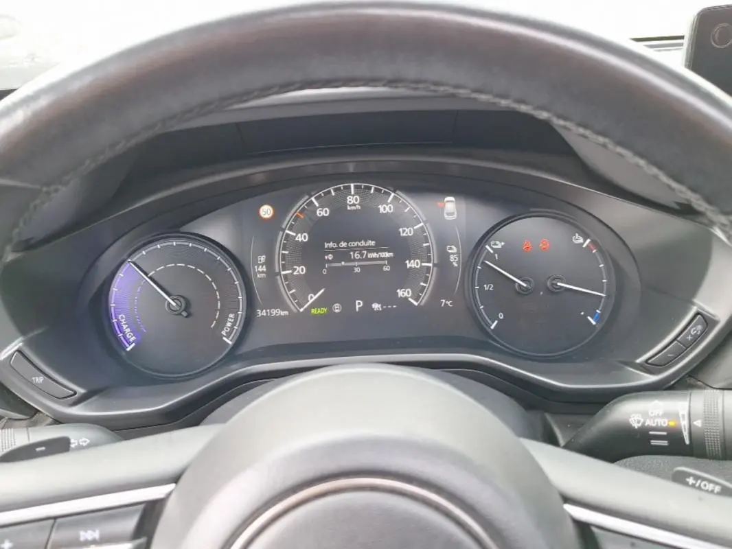 Vue rapprochée du tableau de bord gris du Mazda MX-30 électrique 2021, affichant la vitesse, autonomie et température.