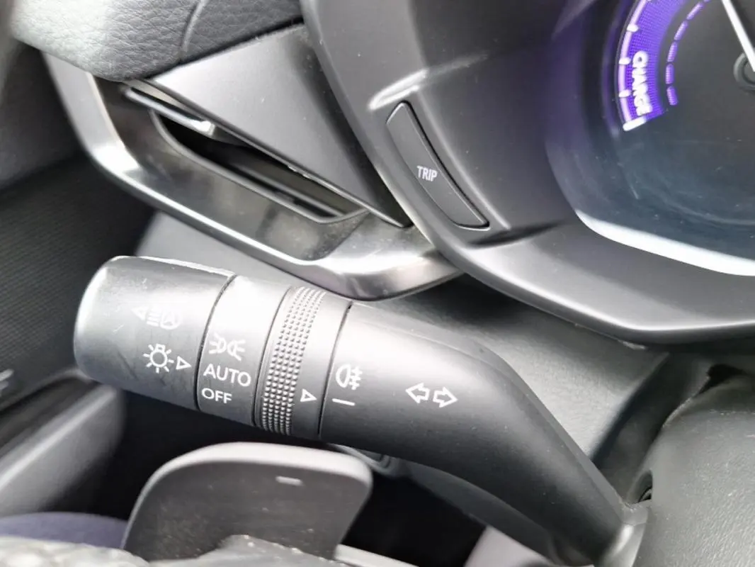 Gros plan sur la commande des feux et clignotants côté gauche du tableau de bord gris d'une Mazda MX-30 électrique 2021.