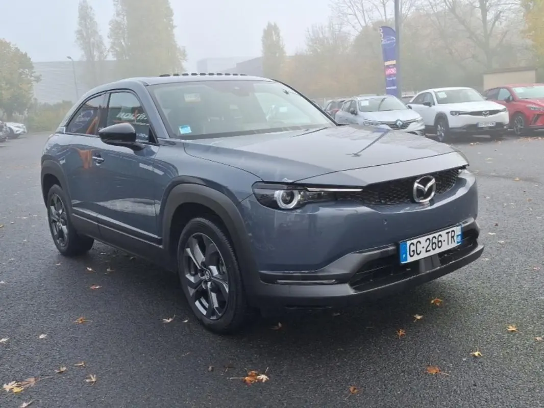 Vue 3/4 avant d'un Mazda MX-30 gris électrique 2021 avec calandre noire et jantes spécifiques version Industrial Vintage.