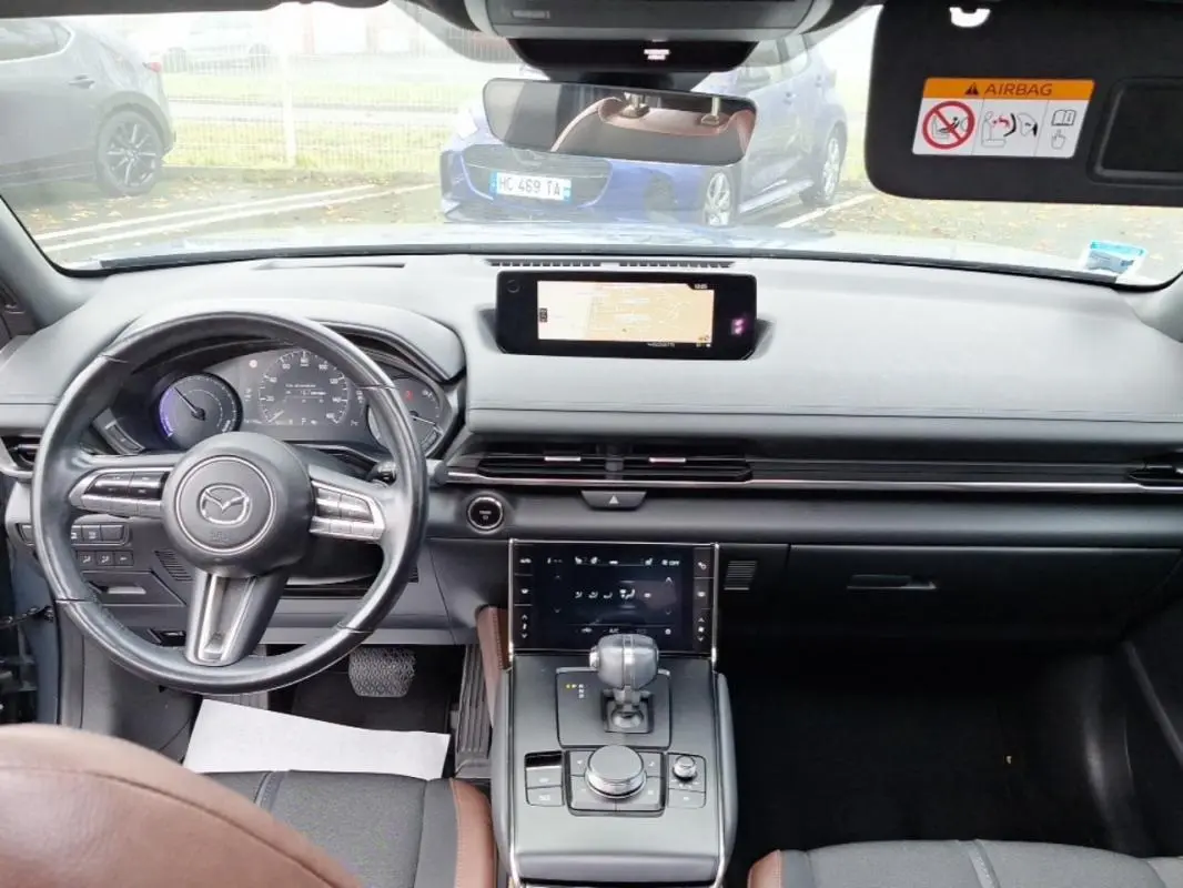 Vue intérieure avant du Mazda MX-30 gris 2021, avec tableau de bord moderne et écran tactile central.