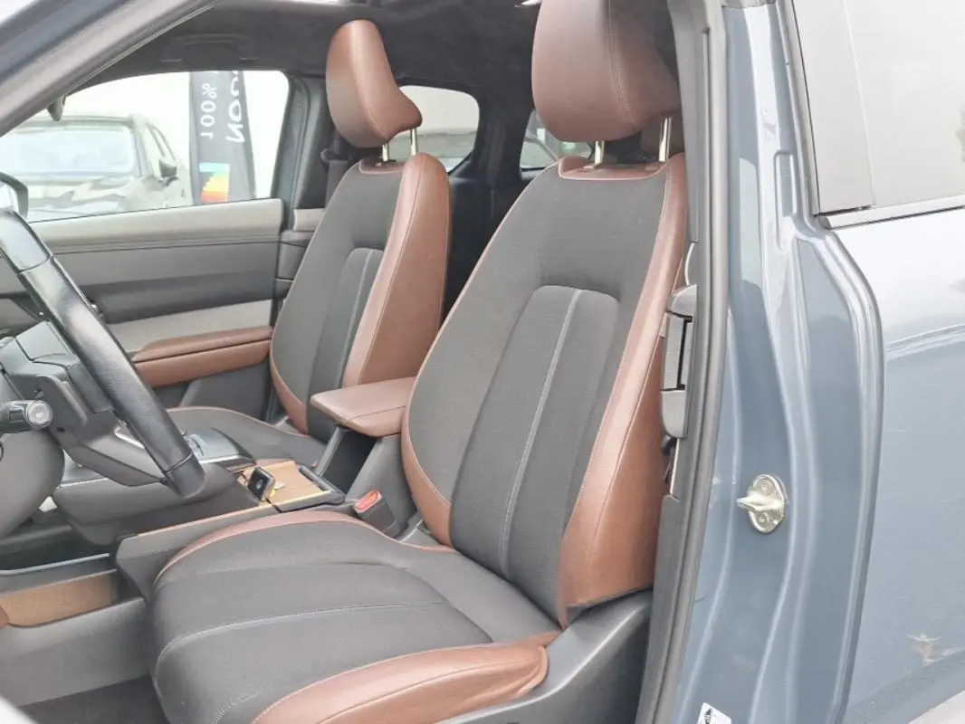 Vue intérieure côté gauche du Mazda MX-30 gris 2021, sièges bi-matière marron et tissu gris, volant et console visibles.