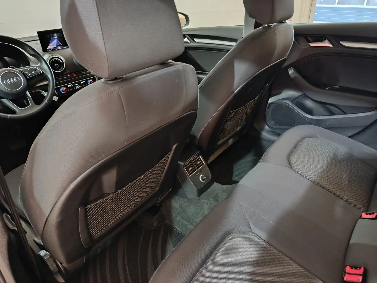 Vue intérieure arrière de l'Audi A3 35 TDI 2020, sièges tissu gris foncé avec aérateurs centraux et tableau de bord visible.