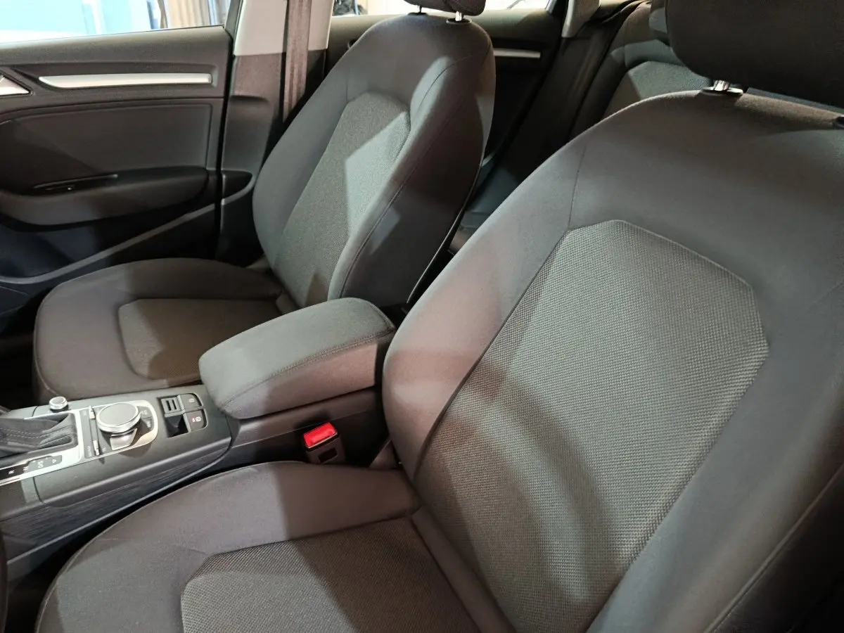 Vue intérieure rapprochée des sièges avant gris foncé et de la console centrale d'une Audi A3 35 TDI 2020.