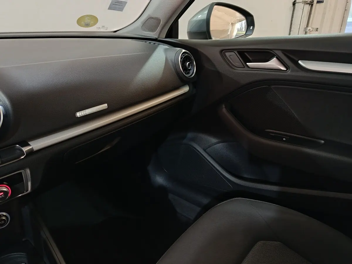 Vue intérieure côté passager de l'Audi A3 35 TDI 2020 avec tableau de bord noir et aérateurs ronds chromés.
