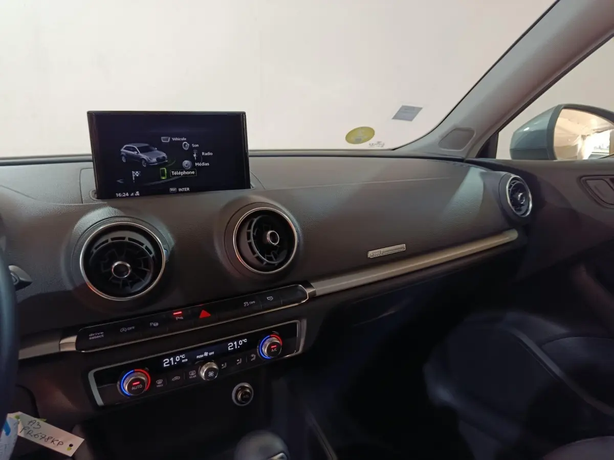Vue intérieure côté passager de l'Audi A3 35 TDI 2020, tableau de bord noir avec écran multimédia central allumé.