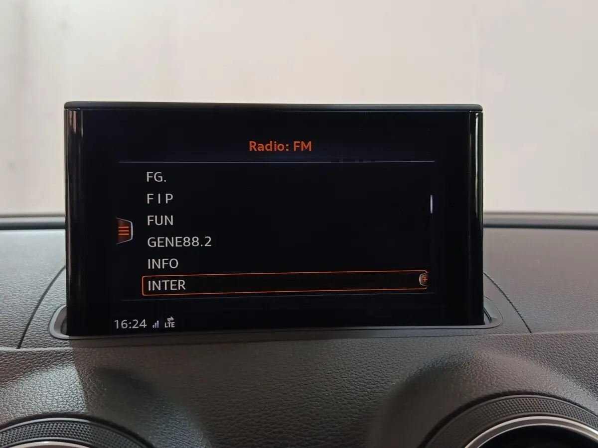 Écran central affichant les stations radio FM dans l’habitacle d’une Audi A3 gris foncé, vue de face.