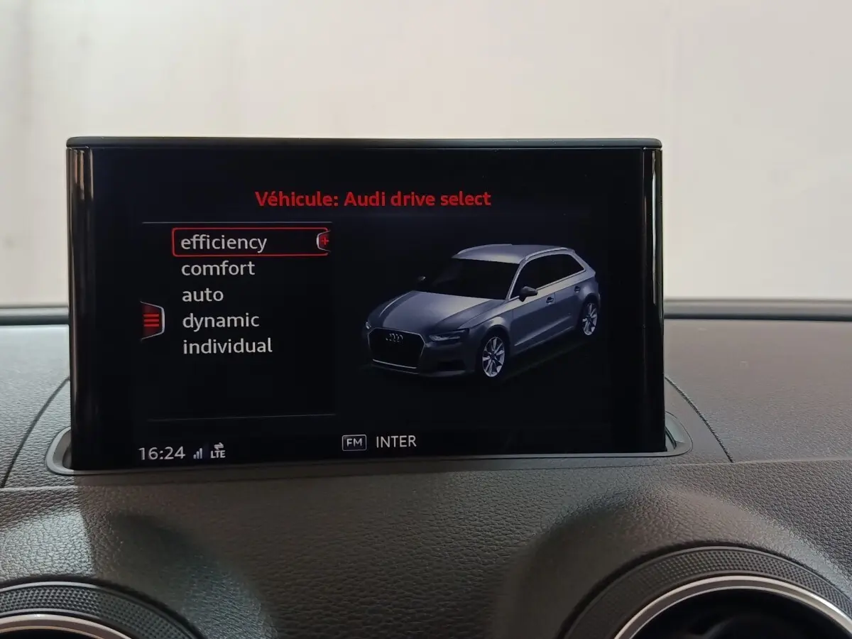 Écran central montrant une Audi A3 gris foncé en vue 3/4 avant avec options de mode de conduite.