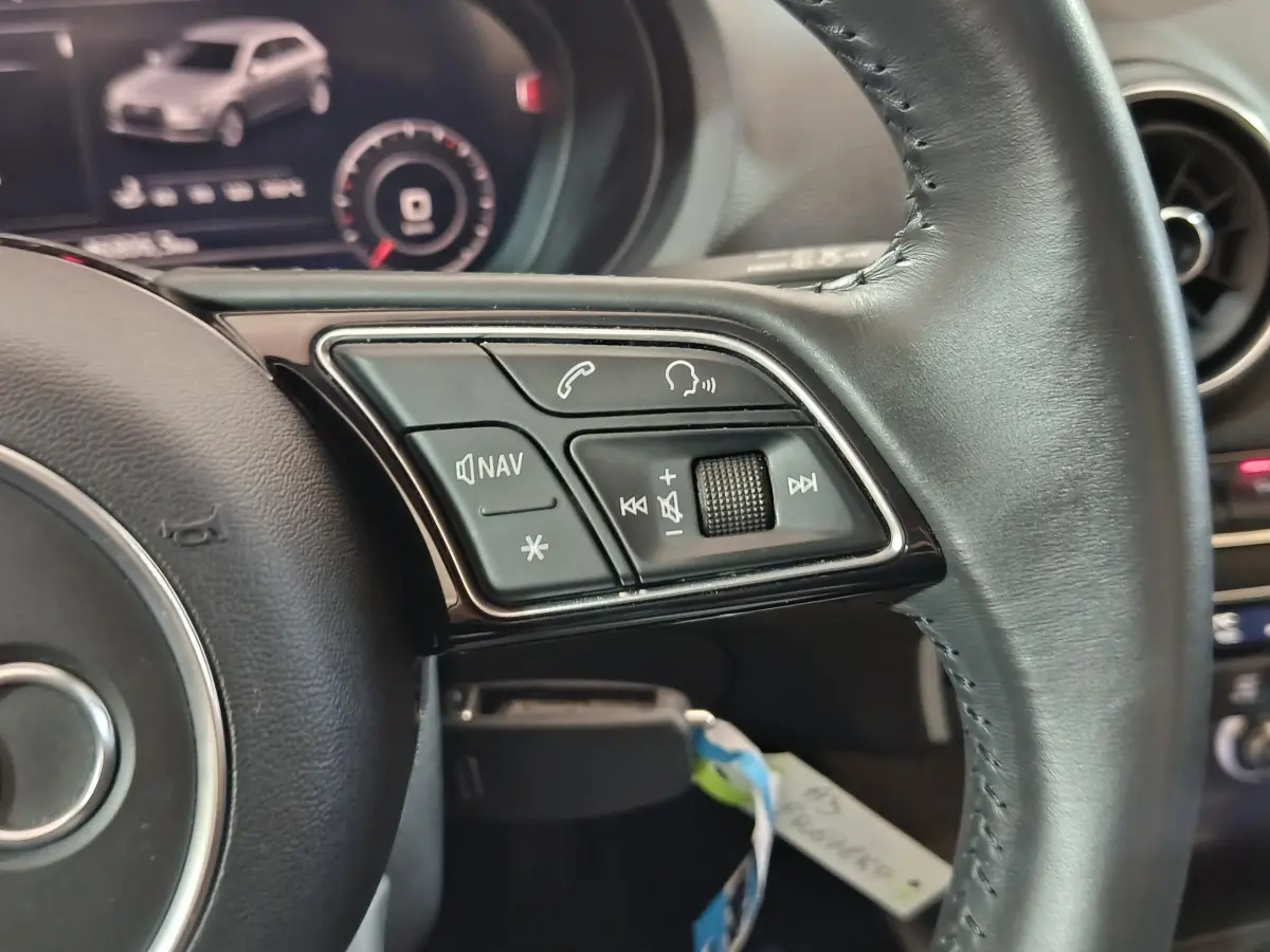 Gros plan sur les commandes multifonctions du volant cuir noir de l'Audi A3 35 TDI Business Line 2020.