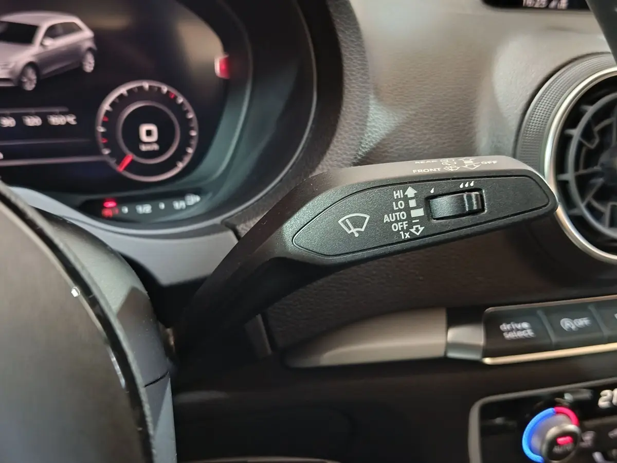 Gros plan sur la manette d’essuie-glace côté gauche du tableau de bord d’une Audi A3 gris foncé 2020.