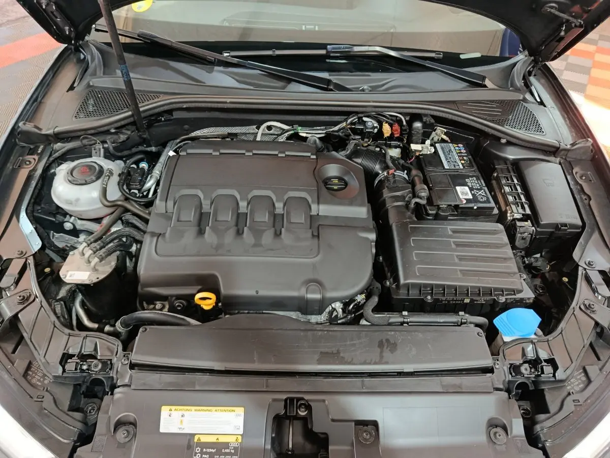 Vue plongeante sur le moteur diesel gris foncé d'une Audi A3 35 TDI 150 S tronic Business Line 2020 avec capot ouvert.