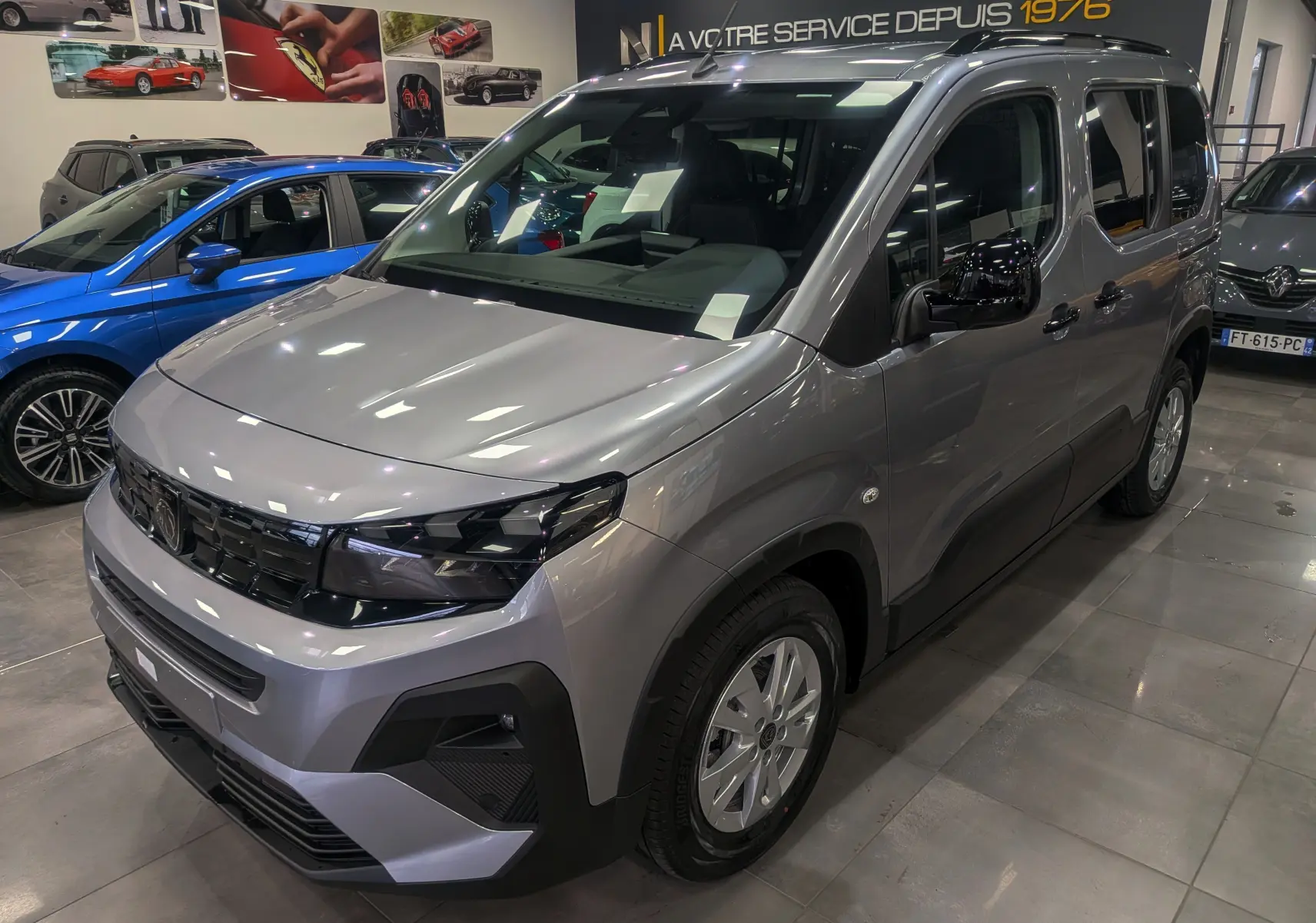 Peugeot Rifter gris acier en vue 3/4 avant droit, avec calandre noire et jantes alliage 16 pouces visibles.