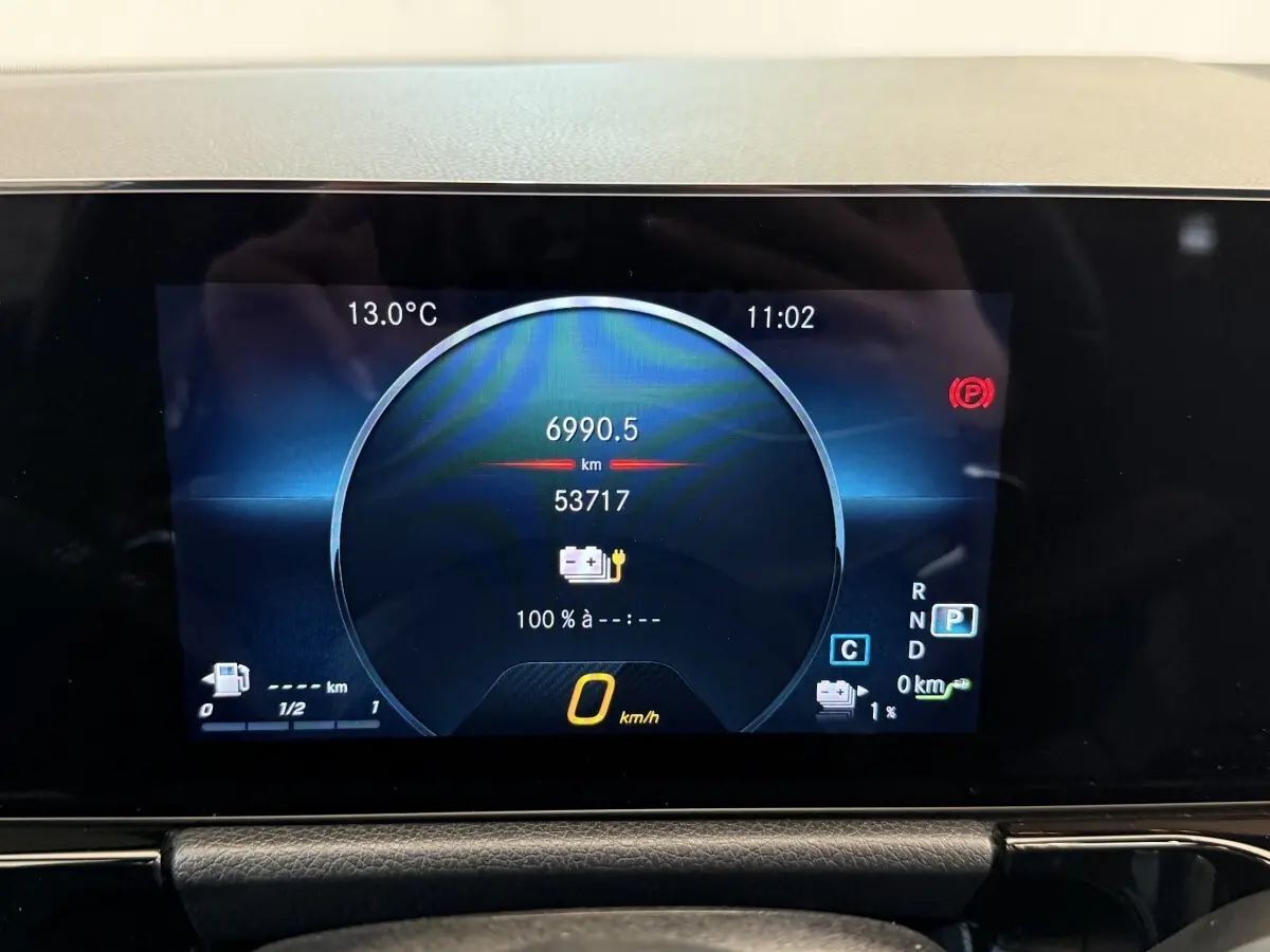 Affichage numérique du tableau de bord de la Mercedes GLA 250 e AMG Line 2023, montrant vitesse et autonomie batterie.