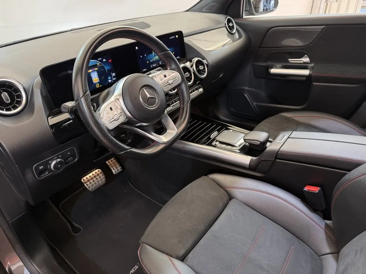 Vue intérieure côté conducteur du Mercedes GLA 250 e AMG Line 2023, avec volant cuir noir et écran tactile double.
