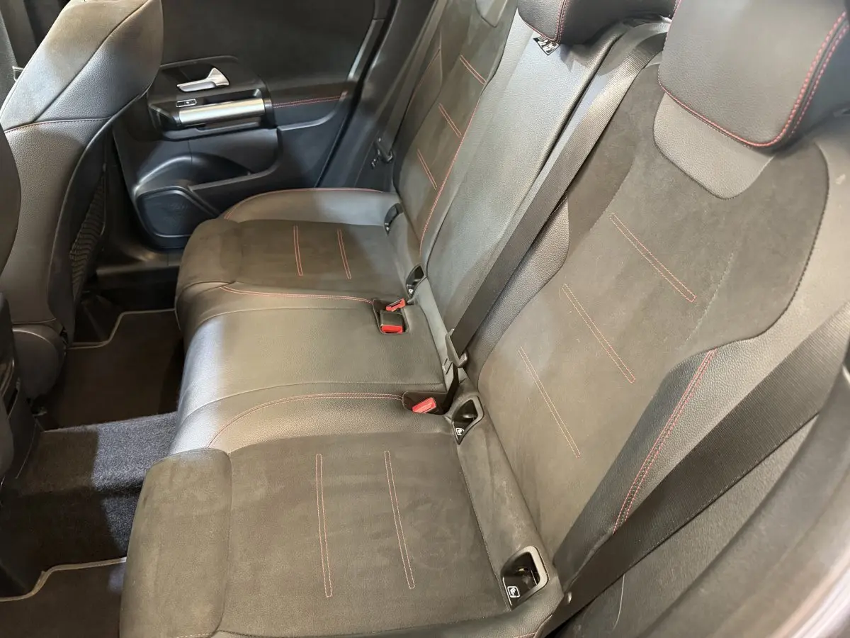 Vue intérieure côté droit montrant la banquette arrière en cuir noir avec surpiqûres rouges du Mercedes GLA 250 e AMG Line 2023.