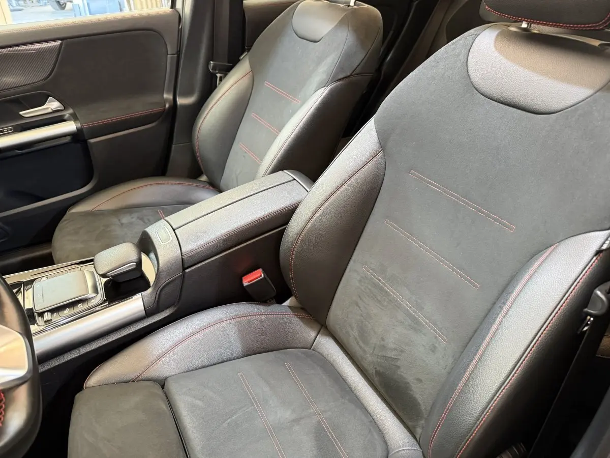 Vue rapprochée des sièges avant en cuir noir avec surpiqûres rouges dans l'habitacle du Mercedes GLA 250 e AMG Line 2023.