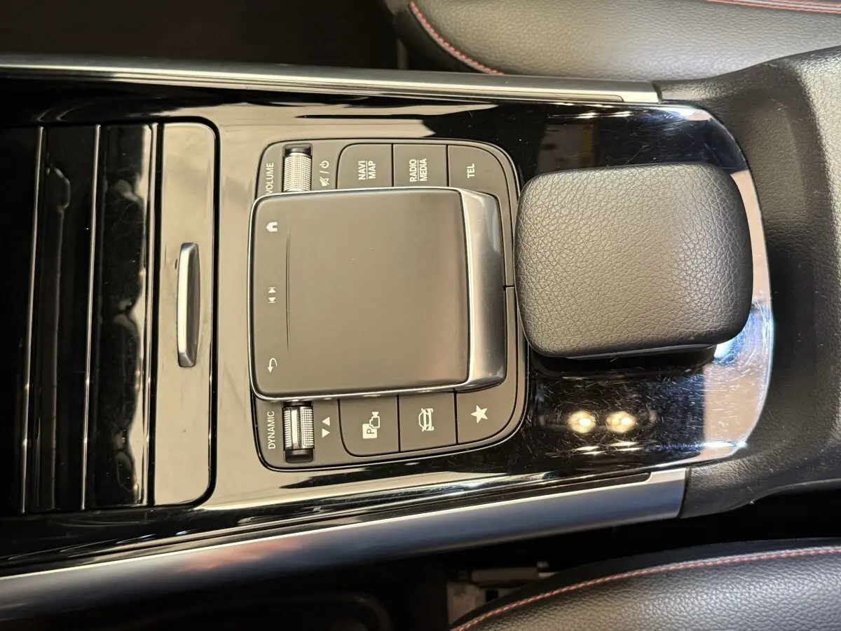 Vue rapprochée du pavé tactile central noir brillant avec commandes multimédia sur Mercedes GLA 250 e AMG Line 2023.