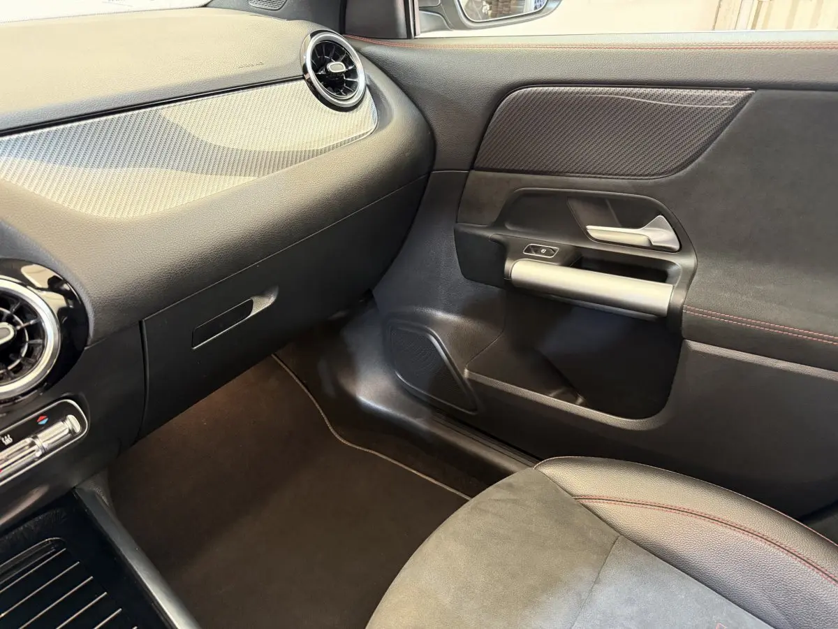 Vue intérieure côté passager du Mercedes GLA 250 e AMG Line 2023, avec tableau de bord noir et garnitures grises.