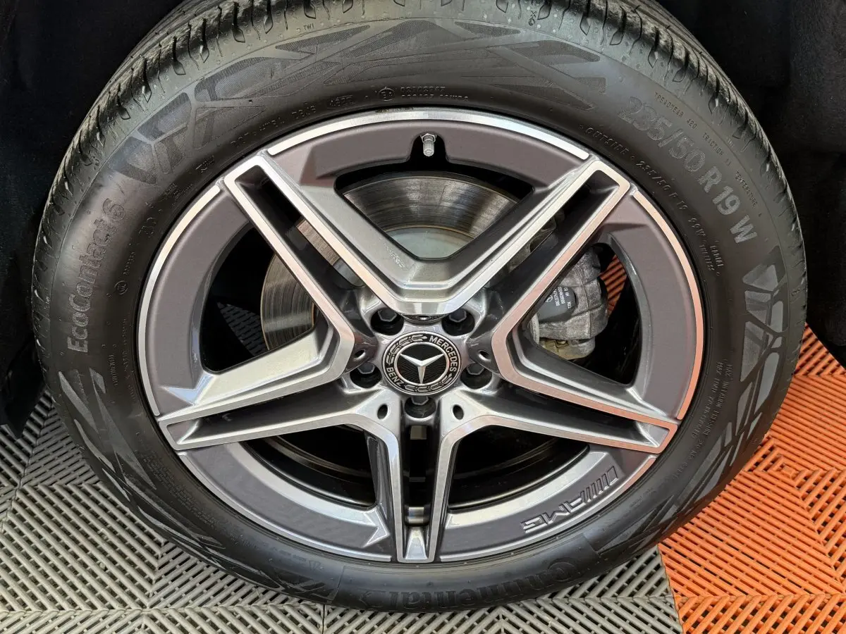 Gros plan sur la jante AMG gris foncé et argentée avec logo Mercedes au centre, montée sur pneu Continental.