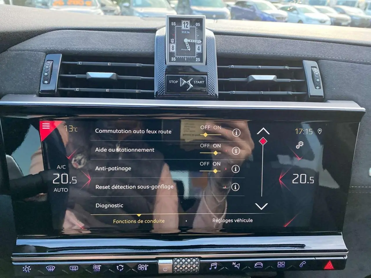 Vue rapprochée de l'écran tactile et de l'horloge digitale du tableau de bord du DS7 Crossback gris foncé.