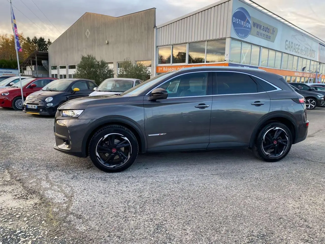 DS7 Crossback gris foncé vu de profil côté gauche, avec jantes noires et détails Performance Line visibles.