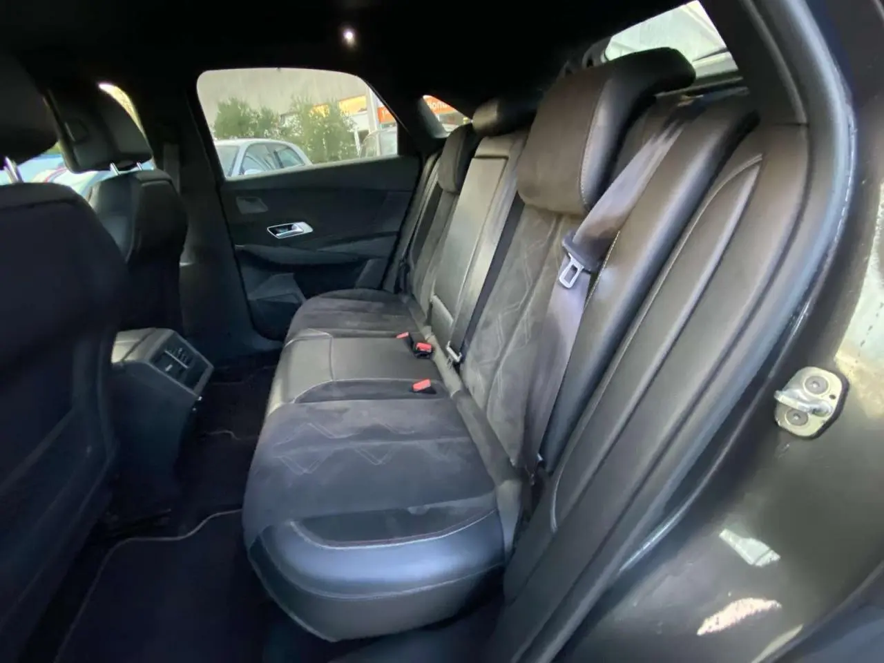 Vue intérieure sur les sièges arrière en cuir noir du DS7 Crossback gris foncé, mettant en valeur l'espace et les finitions raffinées.