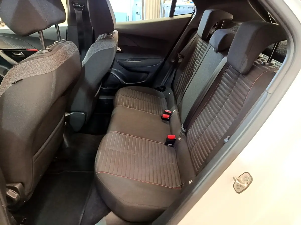 Vue intérieure côté droit montrant la banquette arrière noire avec surpiqûres rouges du Peugeot 2008 blanc de 2021.