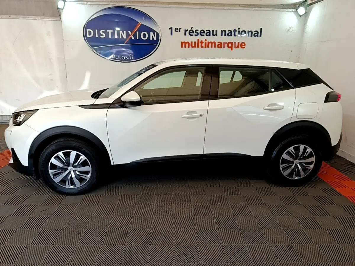Vue latérale droite d'un Peugeot 2008 blanc de 2021 avec jantes alliage et détails noirs contrastants.