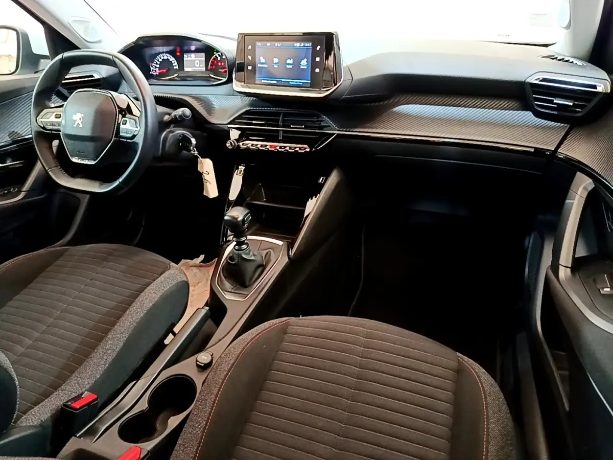Intérieur de la Peugeot 2008 1.5 BlueHDi 2021, vue côté conducteur, tableau de bord avec écran tactile et volant cuir.