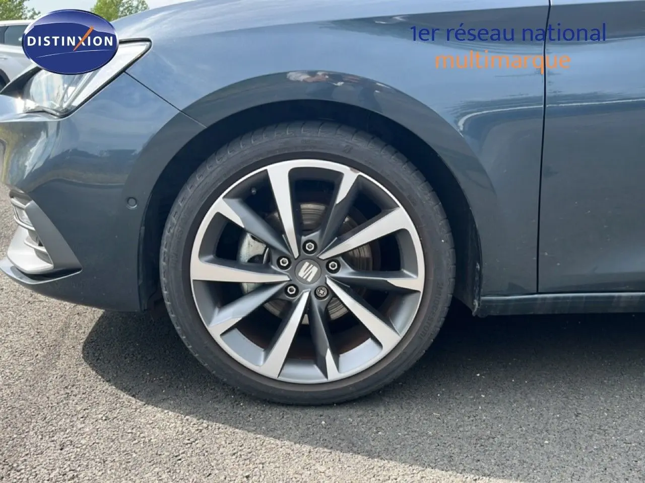 Gros plan sur la roue avant gauche d'une SEAT LEON ST gris magnétique métal avec jante alliage distinctive.