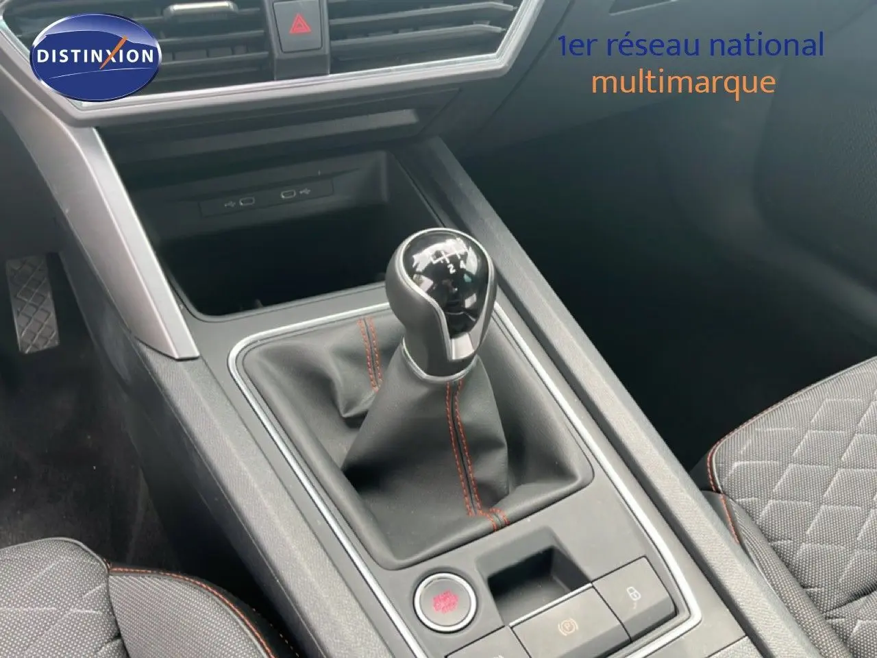 Le levier de vitesses manuel avec surpiqûres rouges dans l'habitacle gris noir du SEAT LEON ST 2025.