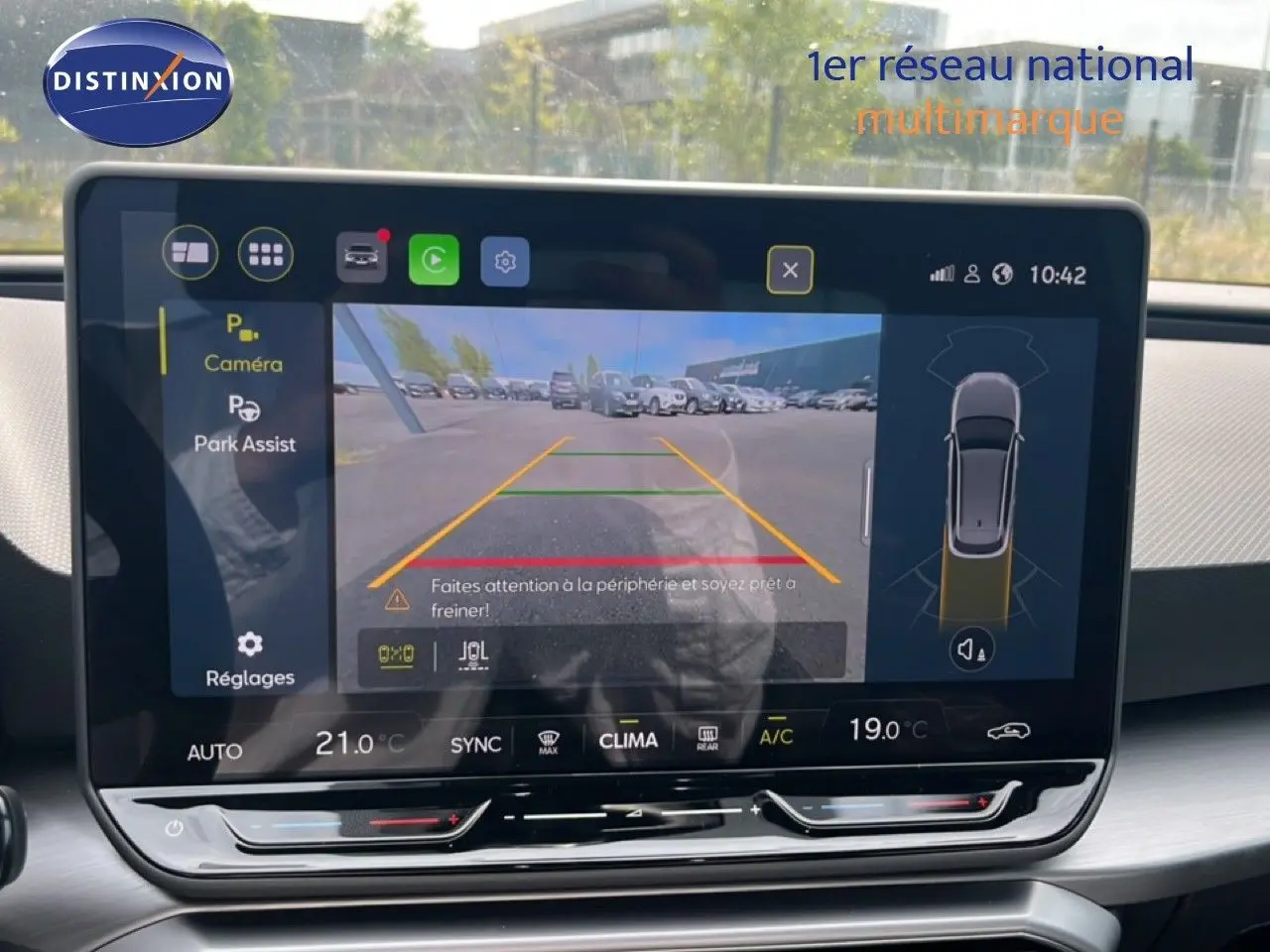 Écran tactile intérieur montrant la caméra de recul du SEAT LEON ST gris magnétique, avec affichage des aides au stationnement.