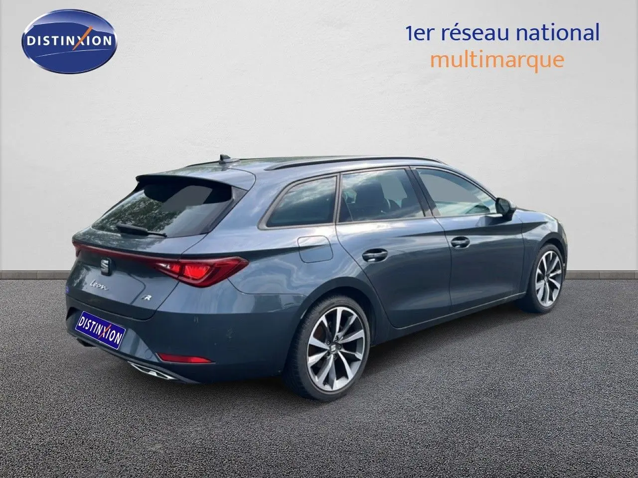 SEAT Leon ST gris magnétique métal vue 3/4 arrière droit, jantes alliage et feux arrière LED distinctifs.